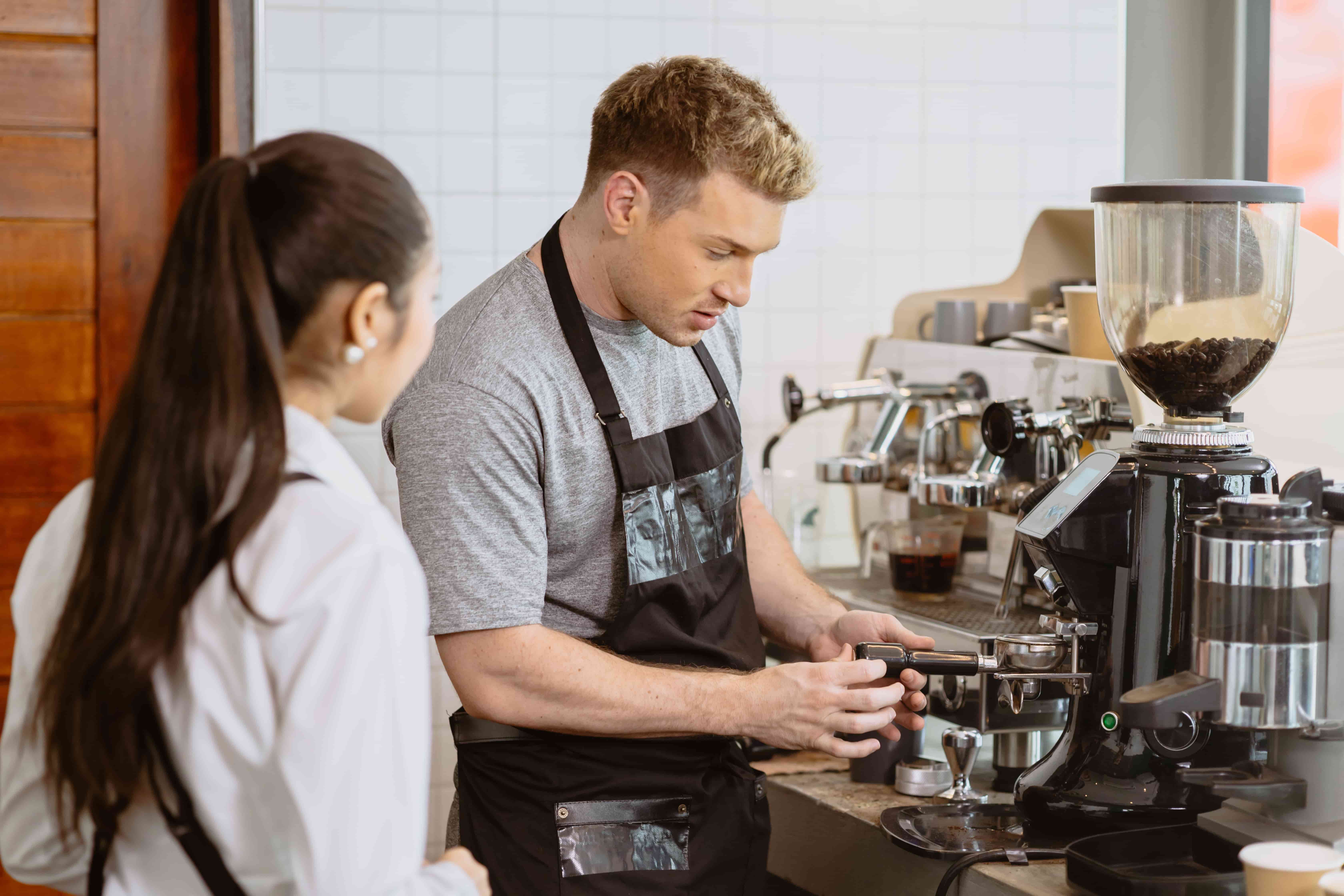 barista teaching a new team member how to make coffee