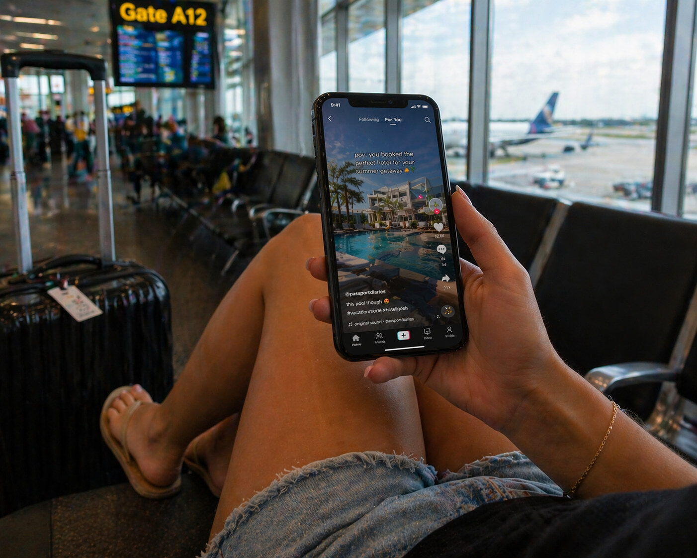 Female traveler in airport lounge scrolling travel content on social media