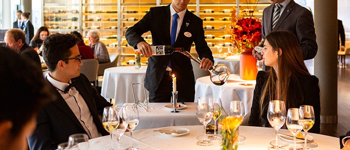 Waiter serves wine in a restaurant.