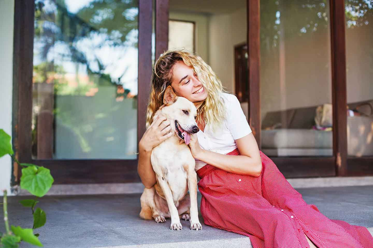 a woman sitting on the steps with her dog