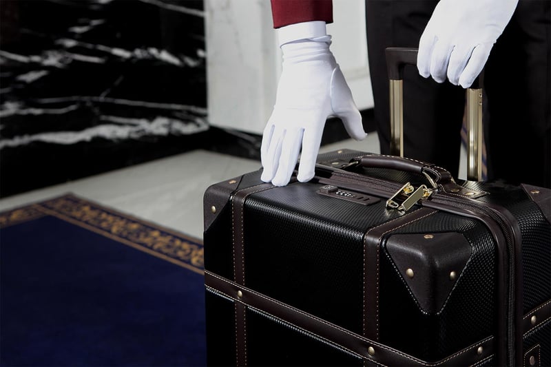 White glove of a bell hop picking up luggage