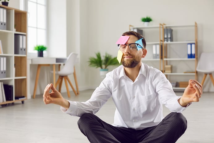 Professional man meditating covered in post-it notes