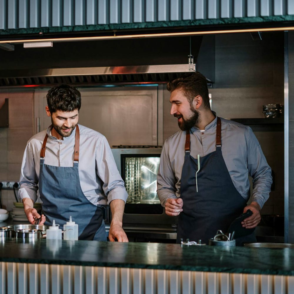 Two people talking and smiling in the kitchen