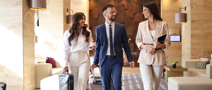 Guests walking through a hotel lobby arriving in a hotel.