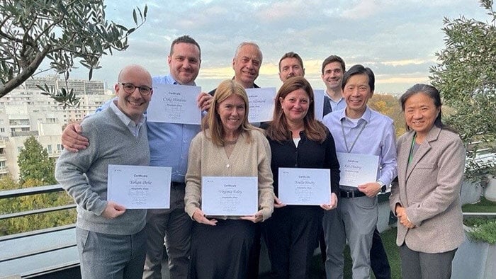 A group of people proudly displaying their Hospitality Vibes certification on a sunny balcony