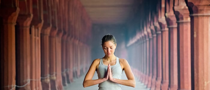 Yogi practising meditation surrounded by columns