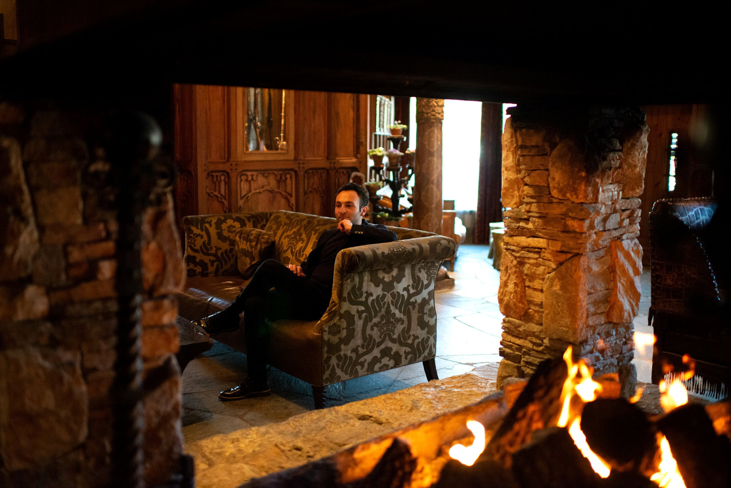 Pensive man contemplating life next to a fireplace