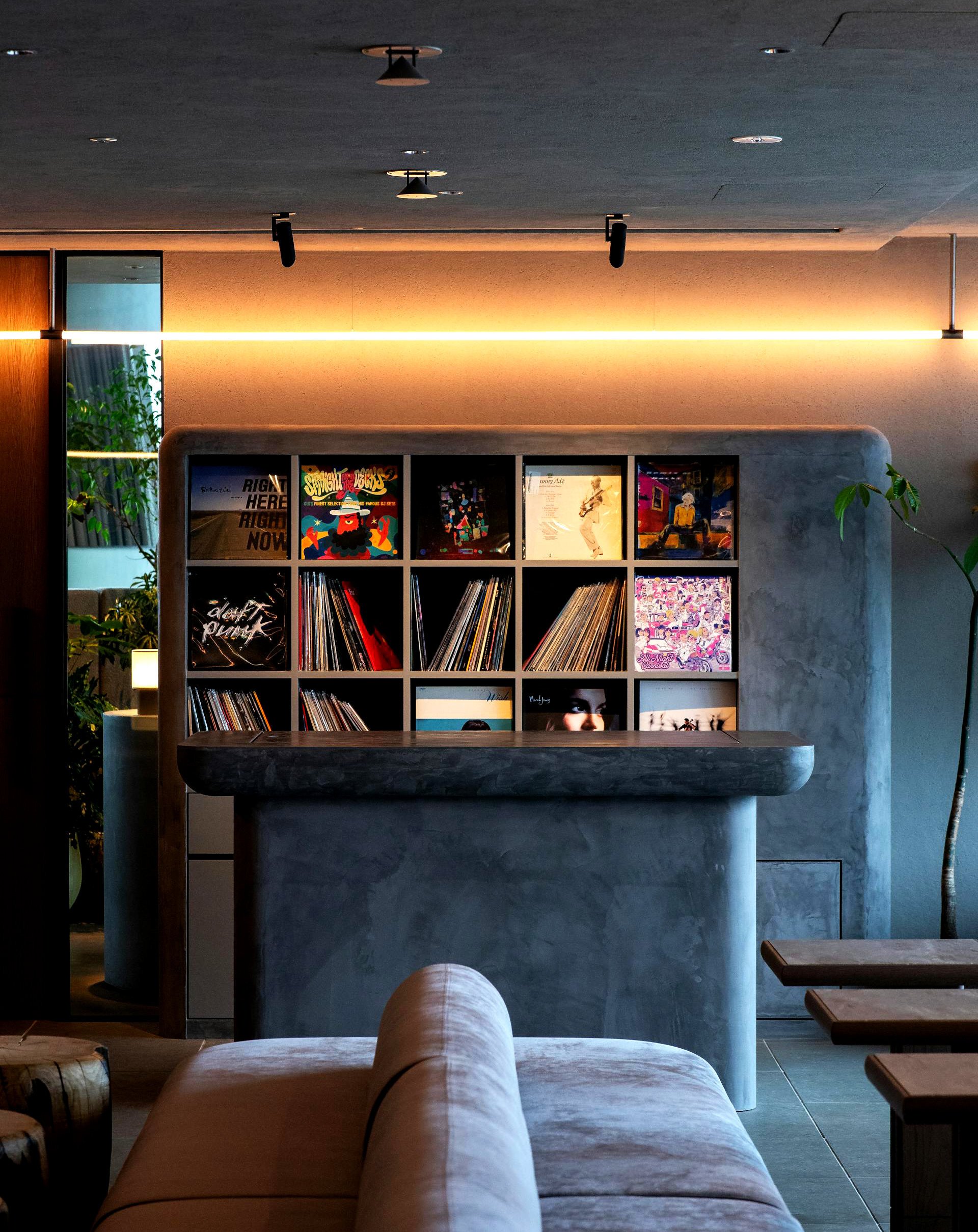 DJ console with a vinyl rack and ambient lighting