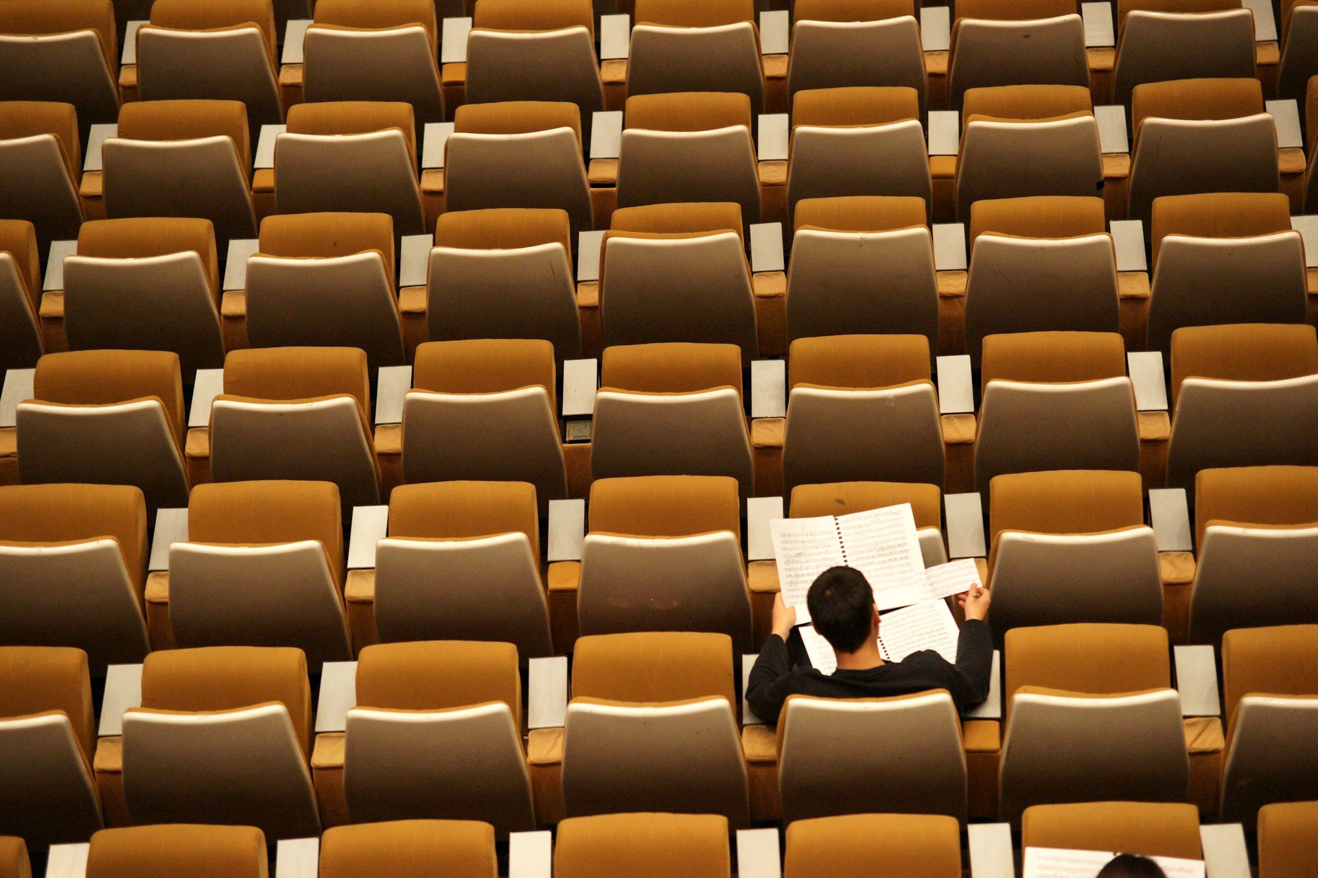 Person reading alone in an auditorium