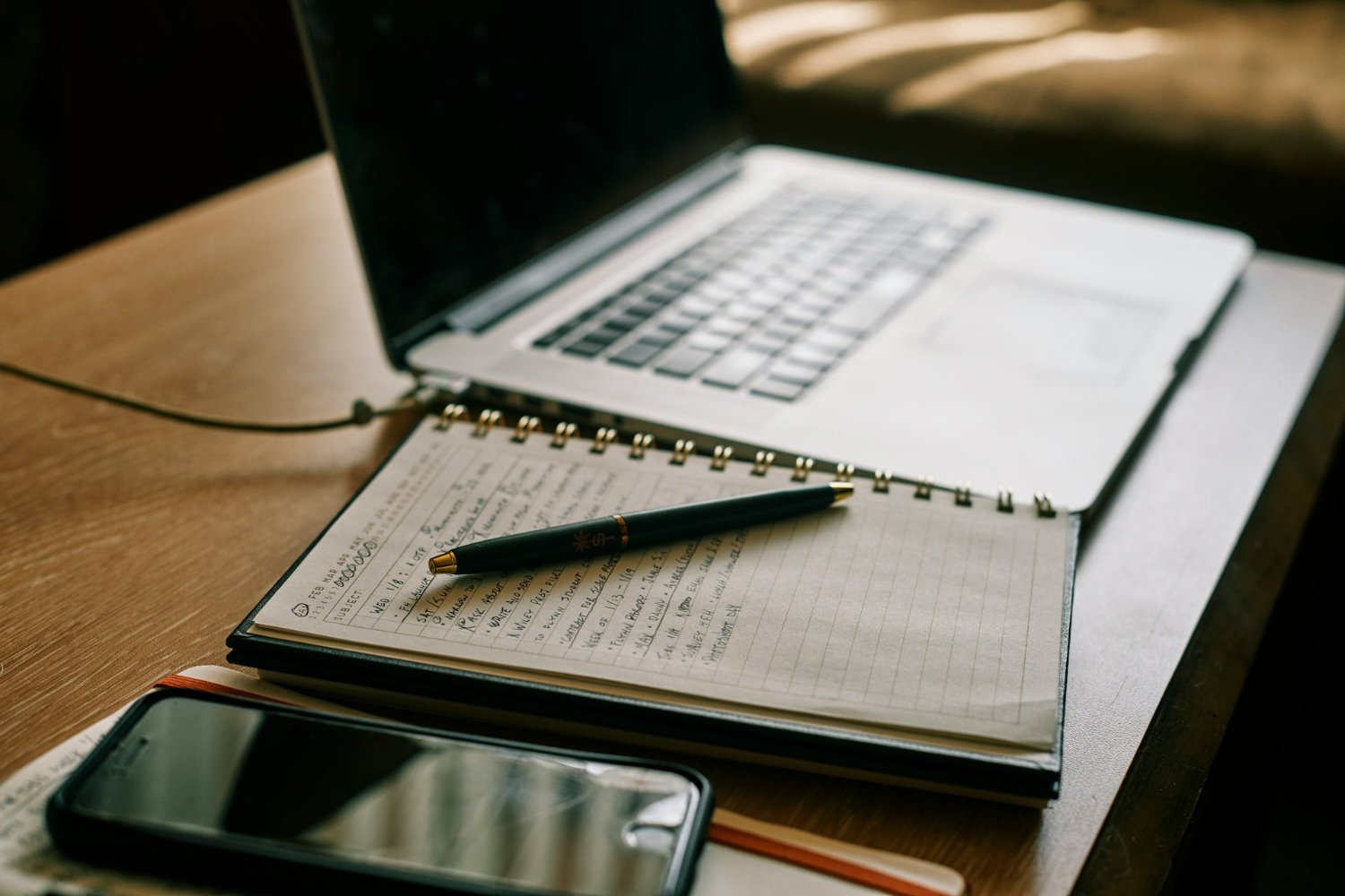 A phone, a notebook, and a laptop