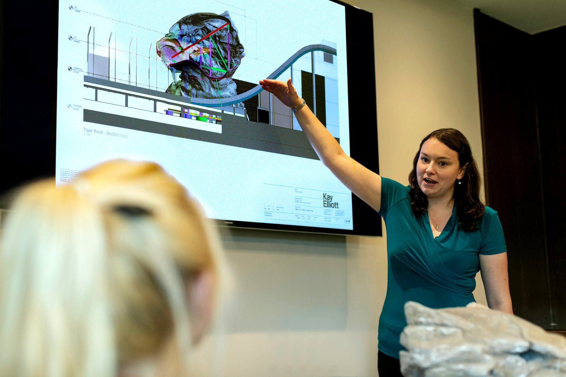 A teacher pointing at a screen